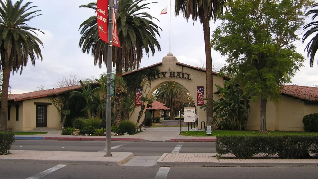 The Spanish-style arched entrance of Brawley City Hall framed by palm trees on Main Street