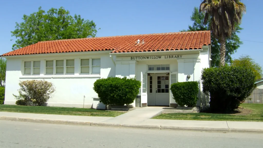 The small white Buttonwillow public library with a red tile roof