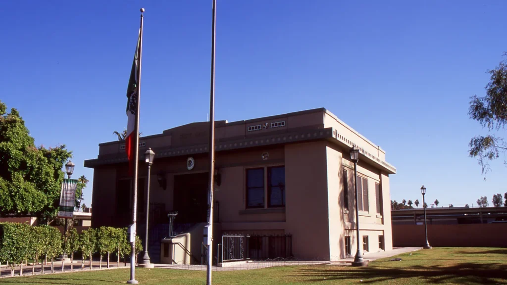 The old Calexico city hall, a brick building with flagpoles on a green lawn