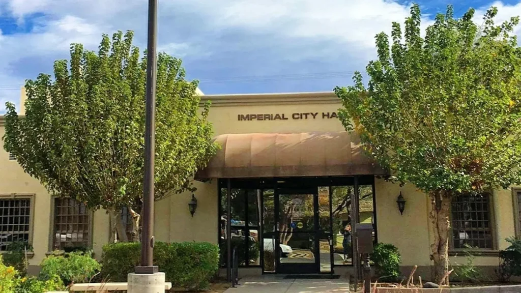 The entrance of Imperial City Hall with trees and a flagpole in front