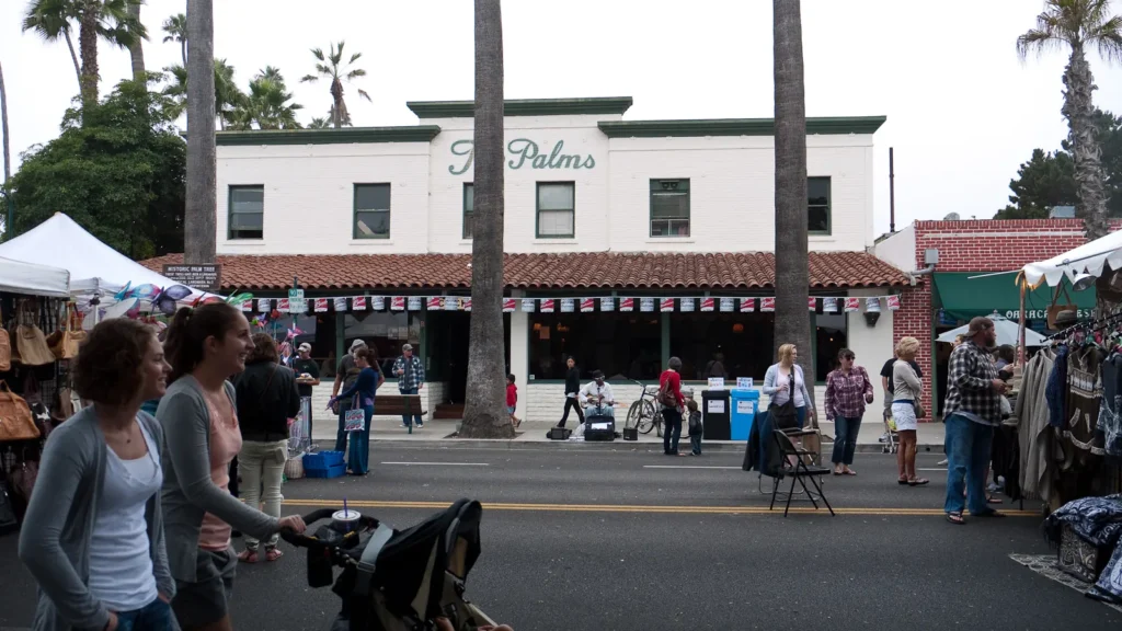 Shoppers on Linden Avenue in downtown Carpinteria, with palm trees and storefronts