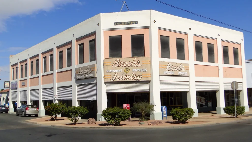 The two-story Rehkopf Building, pink and white with a vintage jewelry sign, on a corner in downtown El Centro