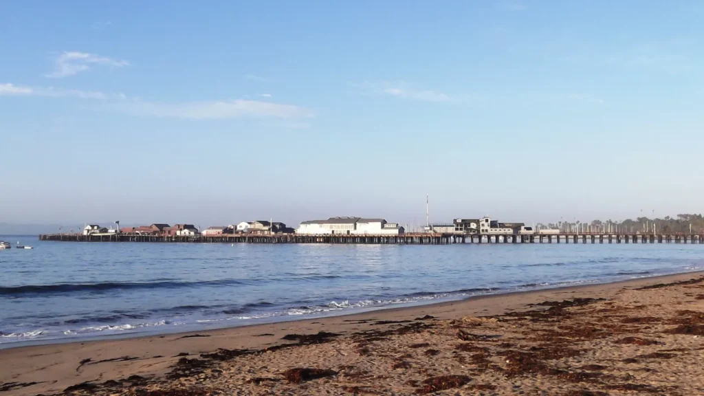 Stearns Wharf reaching into the ocean from a sandy Santa Barbara beach under a blue sky